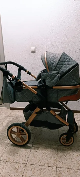 Carrito de bebé gris con detalles dorados