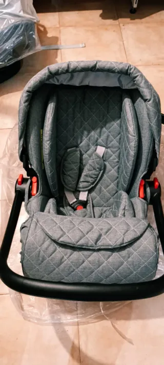 Carrito de bebé gris con detalles dorados