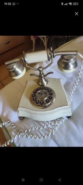 Teléfono antiguo de disco plateado y blanco