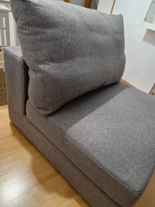 Sillón de tela gris con cabezal reclinabe