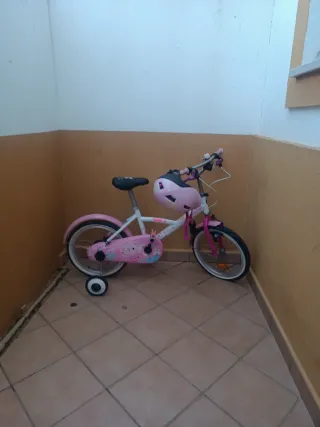 Bicicleta infantil rosa con casco