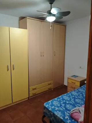 Cama individual con mesita de noche y armarios