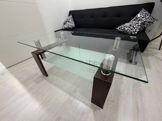 Sofá cama negro y mesa de cristal
