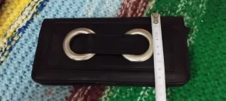 Cartera de cuero negro con aros metálicos