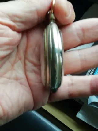 Reloj de bolsillo plateado con cadena