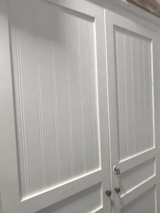 Armario blanco de madera con mesita a juego y cama