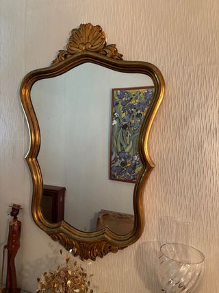 Espejo decorativo dorado con marco curvo