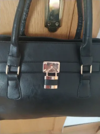Bolso negro con candado dorado