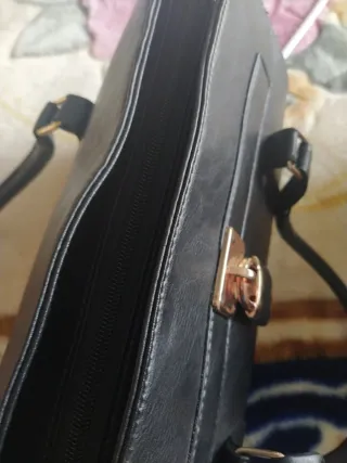 Bolso negro con candado dorado