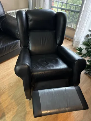 Sofá, sillón y puff de polipiel negro.