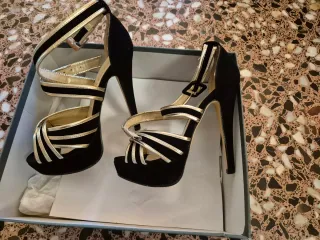 Sandalias fiesta tacón Koi Couture negro/dorado.