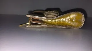 Bolso de fiesta dorado con asa de mano.