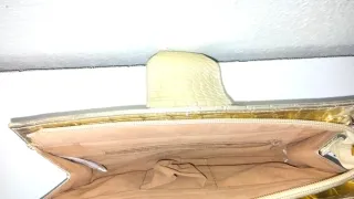 Bolso de fiesta dorado con asa de mano.