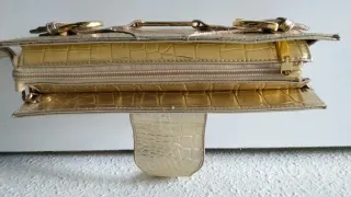 Bolso de fiesta dorado con asa de mano.