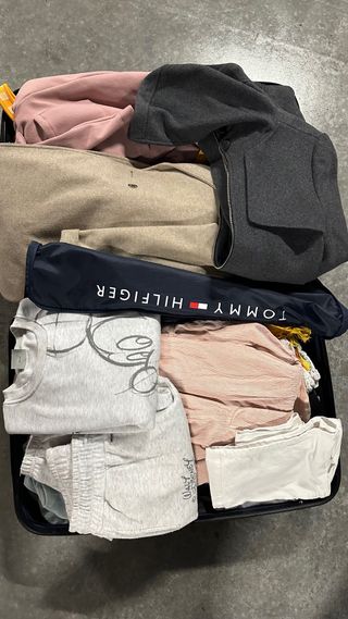 Valigia piena di vari vestiti e accessori