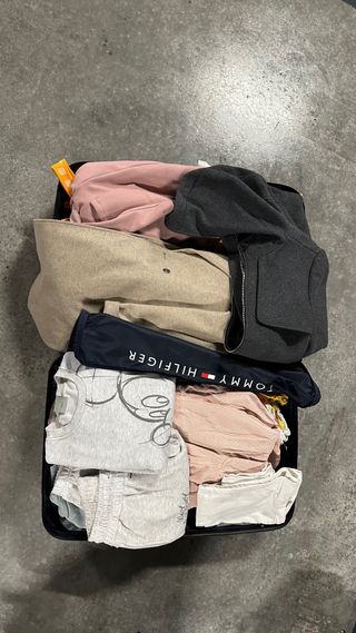 Valigia piena di vari vestiti e accessori