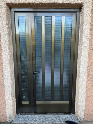 Puerta de entrada marrón con cristal