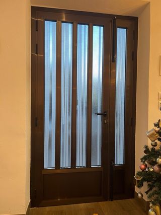 Puerta de entrada marrón con cristal