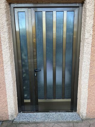 Puerta de entrada marrón con cristal