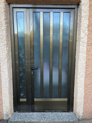 Puerta de entrada marrón con cristal