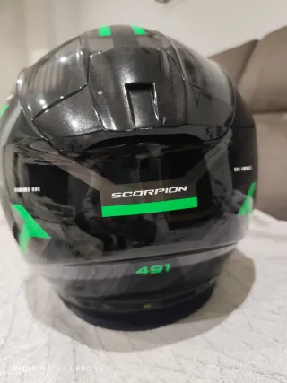 Casco de moto negro con detalles verdes