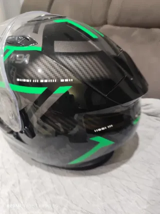 Casco de moto negro con detalles verdes