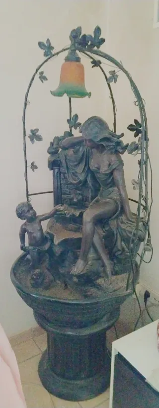 Fuente de agua decorativa con figura iluminada.