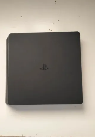 Playstation Slim Negra Sony, un mando y cascos.
