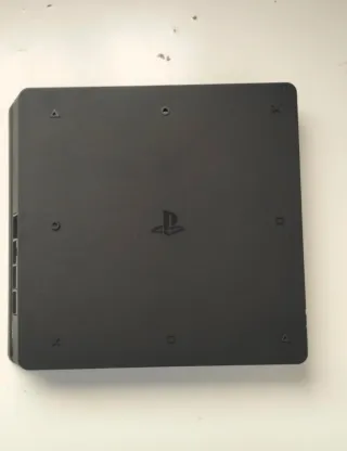 Playstation Slim Negra Sony, un mando y cascos.