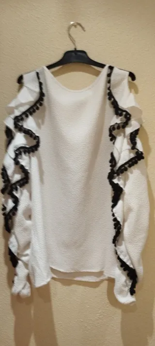 Blusa blanca manga larga con volantes y pompón