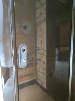 Puerta negra con cerradura y pomos y marco