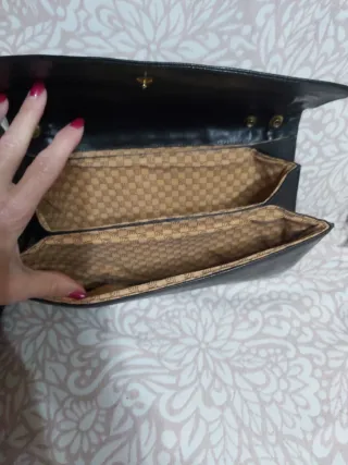 Cartera de piel negra con detalle dorado
