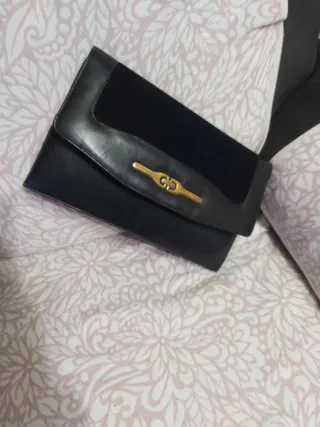 Cartera de piel negra con detalle dorado