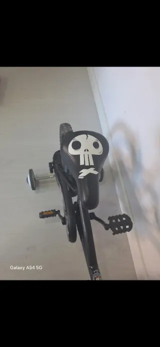 Bicicleta infantil negra con ruedines