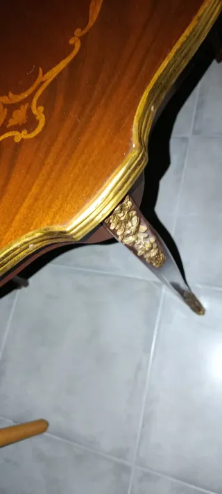 Mesita auxiliar con detalles dorados.