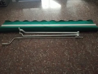 Toldo verde con manivela y soportes.