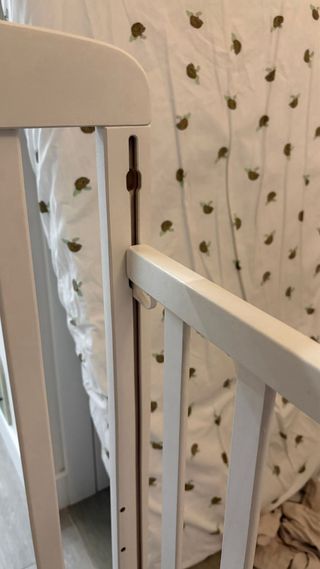 Cuna bebé blanca con dibujos y ruedas