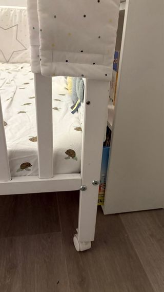 Cuna bebé blanca con dibujos y ruedas