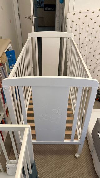 Cuna bebé blanca con dibujos y ruedas