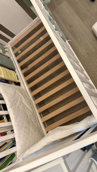 Cuna bebé blanca con dibujos y ruedas