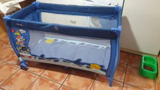Cuna de viaje azul con estampado infantil.