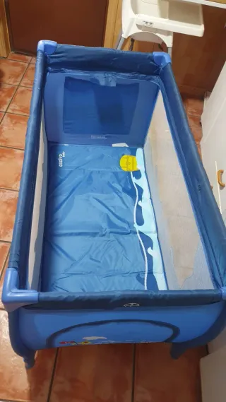 Cuna de viaje azul con estampado infantil.