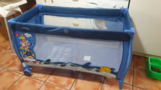 Cuna de viaje azul con estampado infantil.