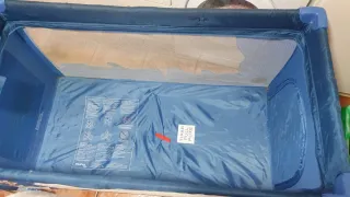 Cuna de viaje azul con estampado infantil.