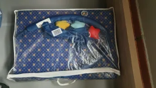 Cuna de viaje azul con estampado infantil.