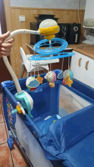 Cuna de viaje azul con estampado infantil.