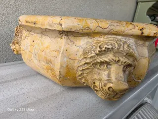 Acquasantiera in marmo con teste di leone