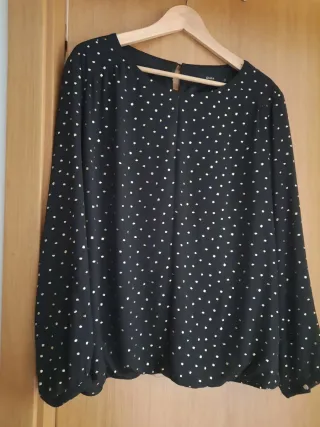 Blusa negra con estampado de estrellas doradas.