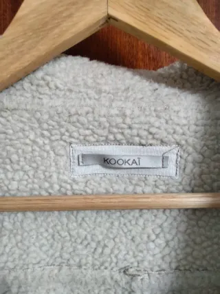 Abrigo de invierno beige y blanco con borreguillo.