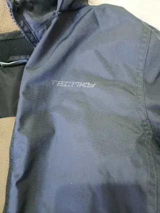 Abrigo azul con capucha, falta cremallera